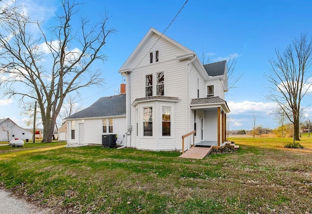 view of front of home with central air condition unit and a front lawn