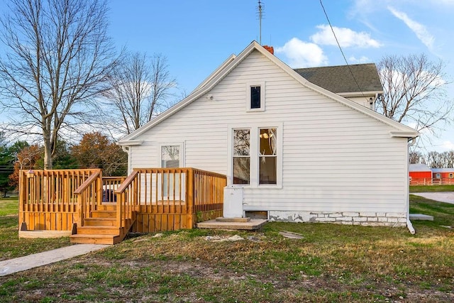 back of house with a wooden deck and a lawn