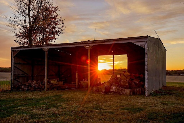 outdoor structure at dusk featuring a yard