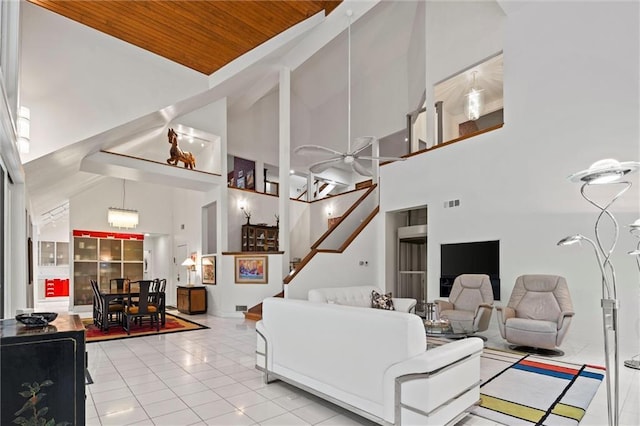 tiled living area with visible vents, high vaulted ceiling, wood ceiling, and stairs