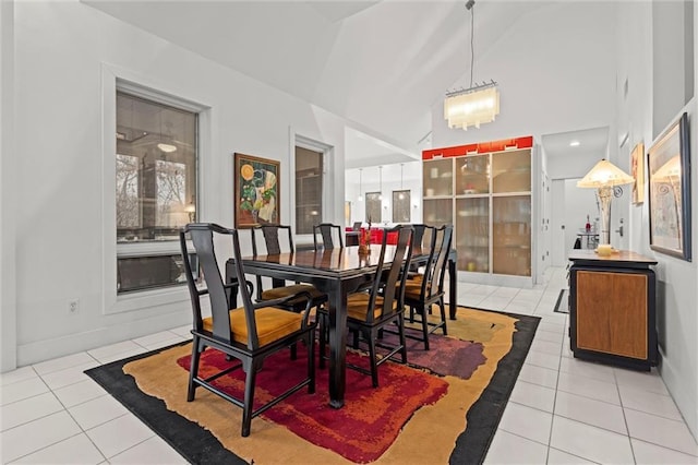 dining room with light tile patterned flooring and high vaulted ceiling