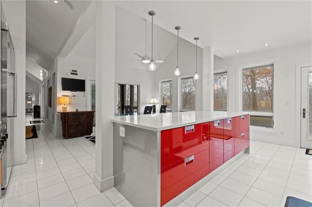 kitchen with light tile patterned floors, plenty of natural light, and high vaulted ceiling