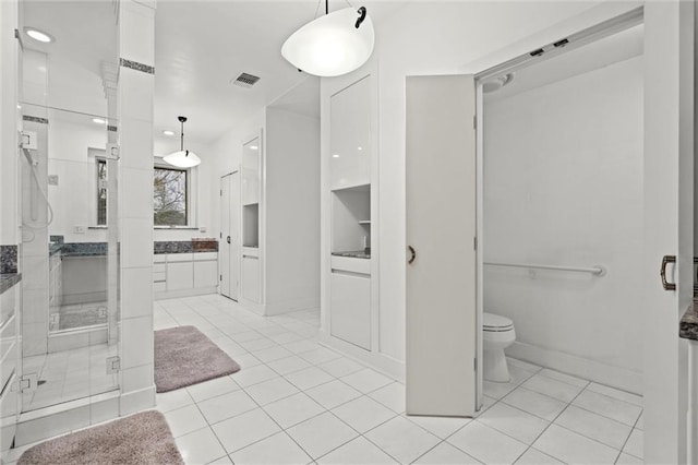 bathroom with vanity, visible vents, a stall shower, tile patterned floors, and toilet