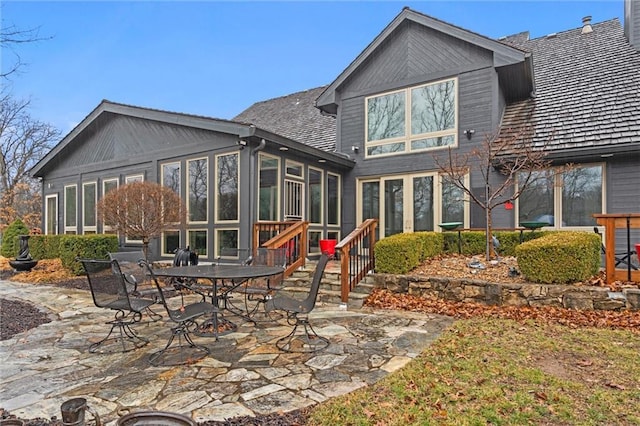 rear view of property with a patio area and a sunroom