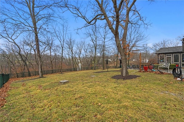 view of yard featuring fence and a sunroom