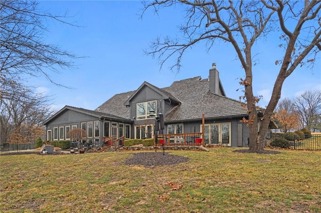 back of house with a yard, fence, a sunroom, and a chimney