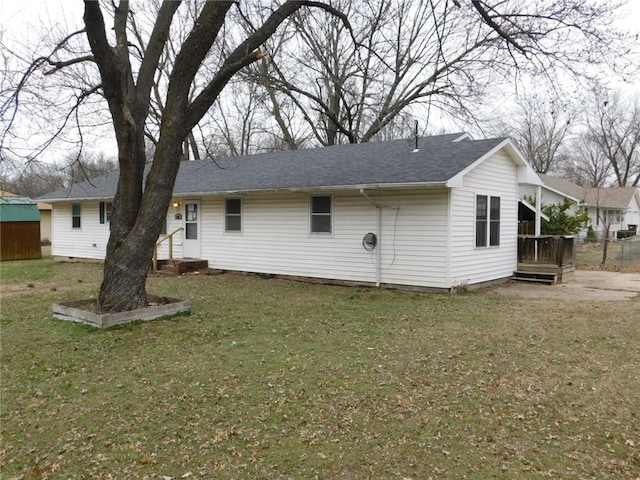 rear view of house featuring a yard