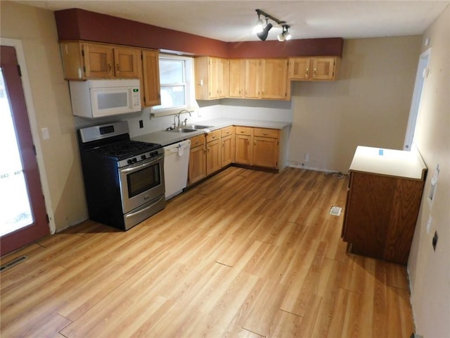 kitchen featuring white appliances, visible vents, a sink, light countertops, and light wood-style floors