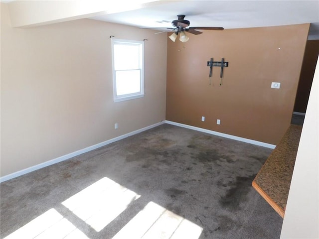 carpeted empty room with ceiling fan and baseboards