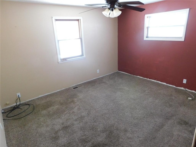 unfurnished room featuring visible vents, carpet floors, and ceiling fan