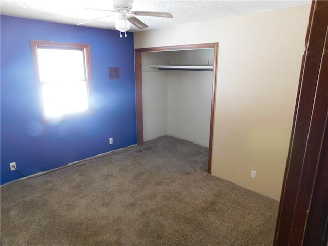 unfurnished bedroom with ceiling fan, a closet, carpet floors, and a textured ceiling