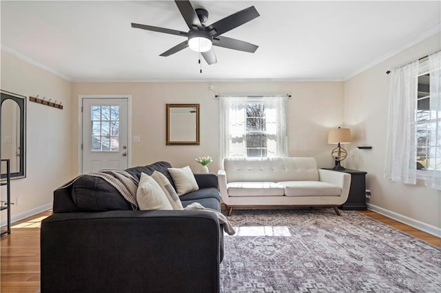 living room with wood finished floors, baseboards, and ornamental molding