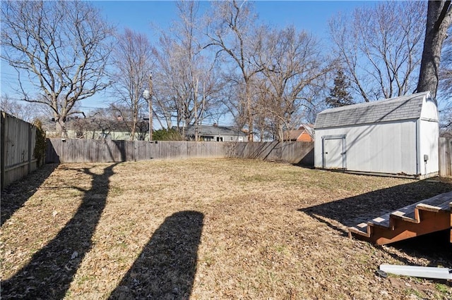 view of yard with a storage unit, an outbuilding, and a fenced backyard