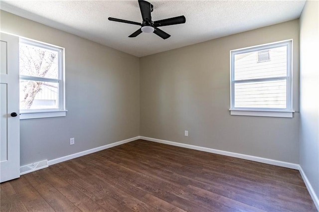 unfurnished room with a ceiling fan, visible vents, wood finished floors, baseboards, and a textured ceiling