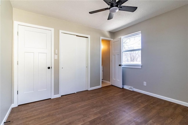 unfurnished bedroom with visible vents, ceiling fan, baseboards, wood finished floors, and a textured ceiling