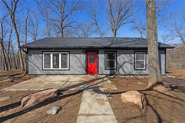 mid-century inspired home featuring metal roof and a patio