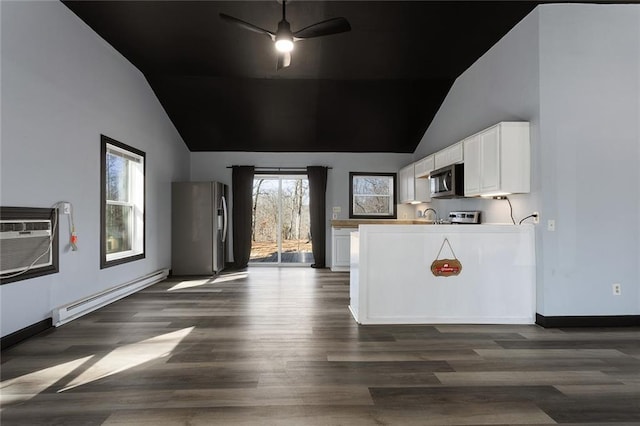 kitchen featuring a wall mounted AC, a baseboard heating unit, dark wood-style floors, white cabinetry, and appliances with stainless steel finishes