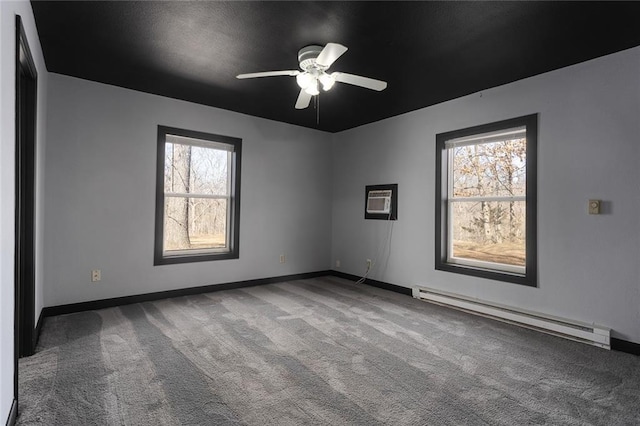 carpeted empty room featuring a ceiling fan, baseboards, baseboard heating, and a wall mounted AC