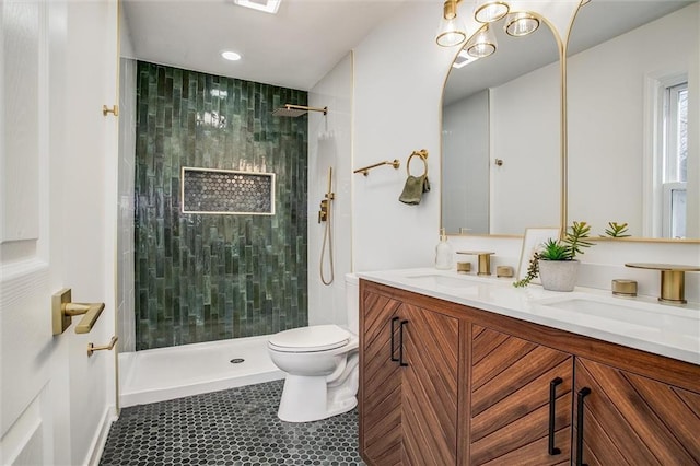 full bath with a tile shower, double vanity, toilet, and a sink