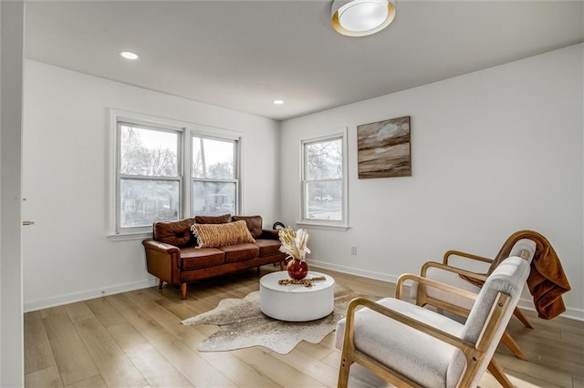 living area with recessed lighting, baseboards, and light wood-style flooring