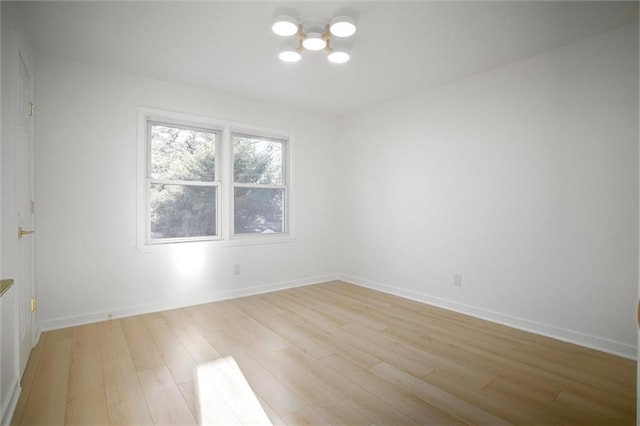 unfurnished room featuring baseboards and light wood finished floors