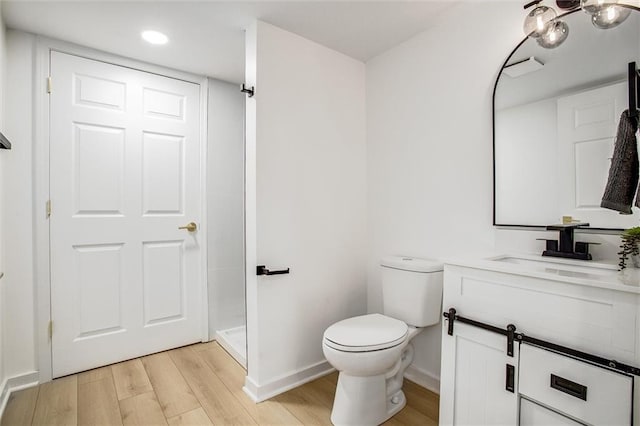 full bathroom with vanity, wood finished floors, baseboards, a shower, and toilet