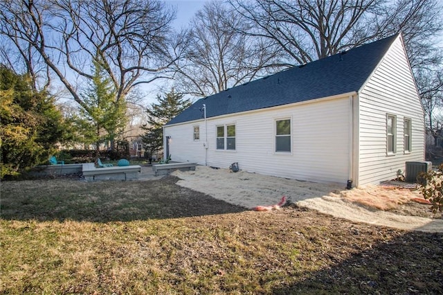 back of property featuring central air condition unit and a shingled roof