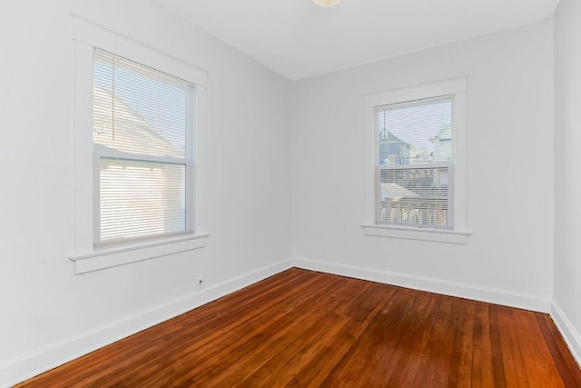 spare room with dark wood-style floors and baseboards