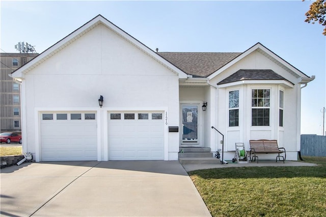 ranch-style home featuring an attached garage, roof with shingles, a front yard, stucco siding, and driveway