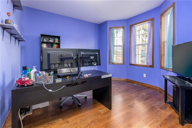 home office featuring visible vents, baseboards, and wood finished floors