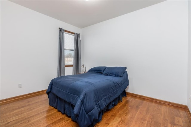 bedroom with light wood-style floors and baseboards