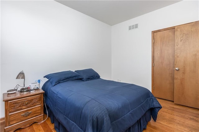 bedroom featuring light wood-style flooring and visible vents