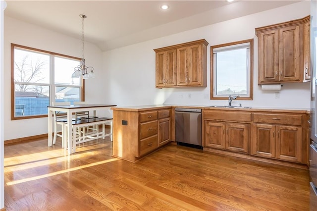 kitchen with dishwasher, a peninsula, brown cabinets, and a sink