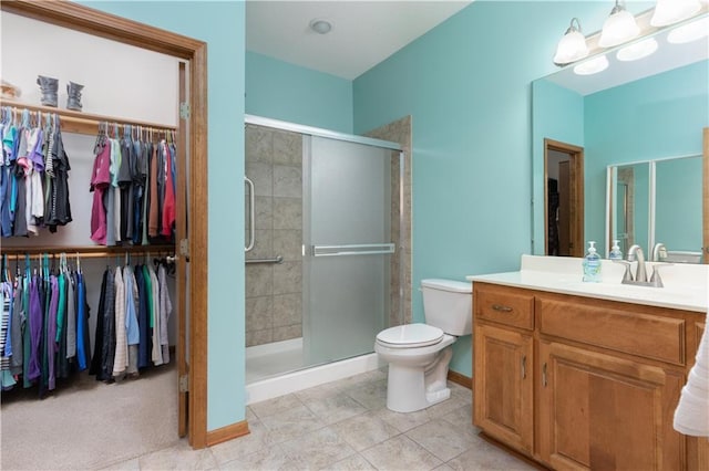 full bath with a shower stall, toilet, vanity, and a walk in closet