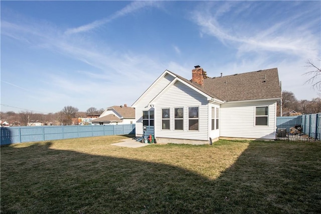 back of property featuring roof with shingles, a yard, a fenced backyard, central AC, and a chimney