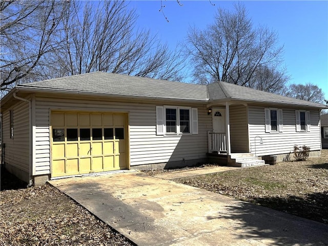 ranch-style house featuring an attached garage, driveway, and roof with shingles