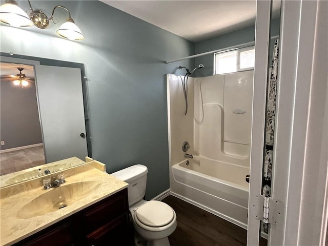 bathroom featuring toilet, wood finished floors, baseboards, bathtub / shower combination, and vanity