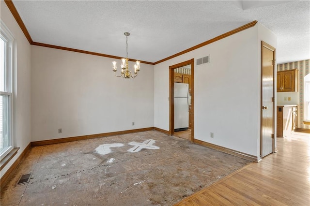 spare room featuring visible vents, baseboards, light wood-style floors, a notable chandelier, and a textured ceiling