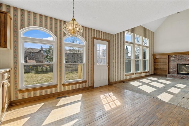 unfurnished sunroom with an inviting chandelier, visible vents, and a wealth of natural light