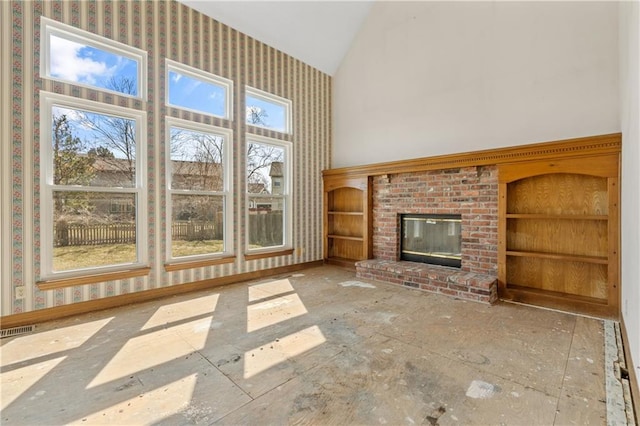 unfurnished living room featuring visible vents, baseboards, high vaulted ceiling, and a healthy amount of sunlight