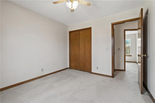 unfurnished bedroom with light carpet, baseboards, a closet, and a ceiling fan