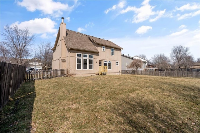 back of house featuring a lawn, entry steps, a fenced backyard, roof with shingles, and a chimney