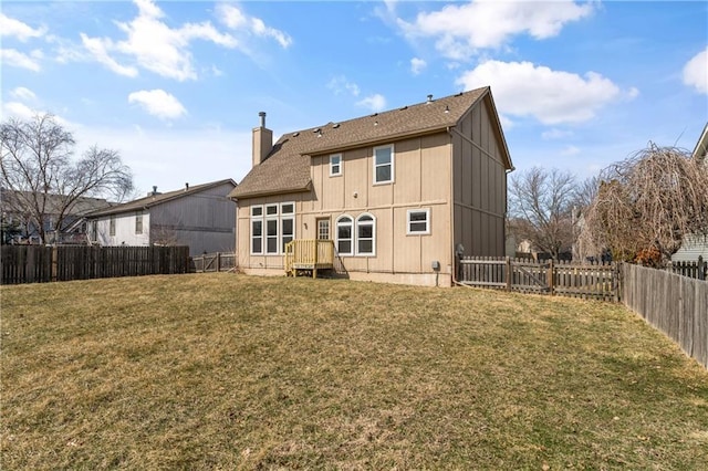 back of property with a lawn, a fenced backyard, a chimney, and a shingled roof