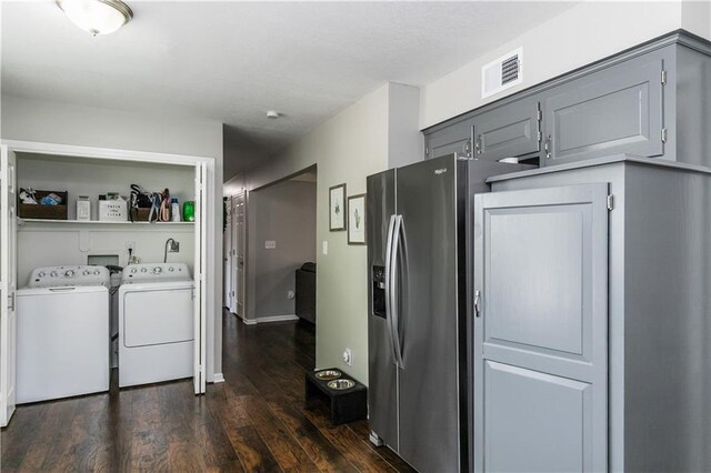 kitchen with visible vents, gray cabinets, dark wood-style floors, and washer and clothes dryer