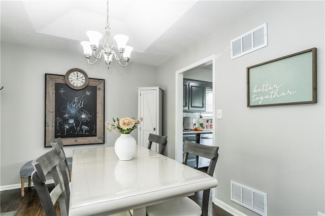 dining area with a notable chandelier, visible vents, dark wood-style floors, and baseboards