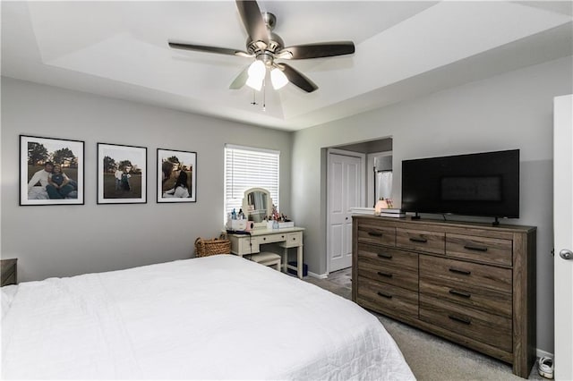 bedroom featuring carpet flooring, a ceiling fan, and a tray ceiling