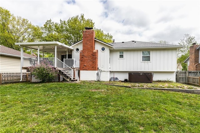 back of house featuring a yard, fence, a chimney, and board and batten siding