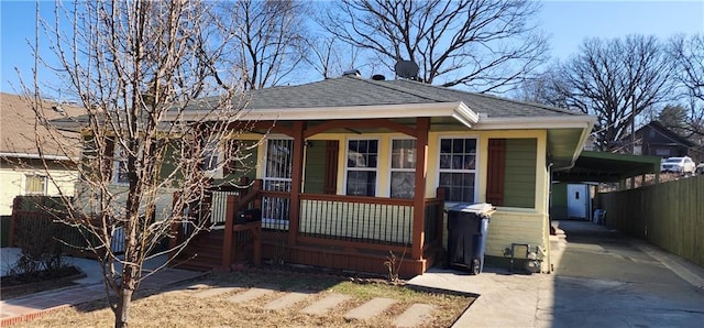 bungalow-style home featuring a carport, a porch, concrete driveway, and a shingled roof