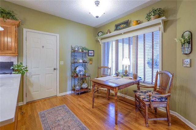 dining space featuring light wood finished floors and baseboards