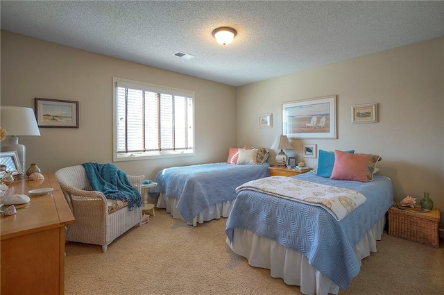 bedroom with light carpet, visible vents, and a textured ceiling